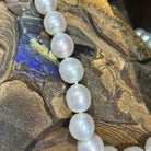 White South Sea pearl strand curving across ironstone with blue opal colour in the rock