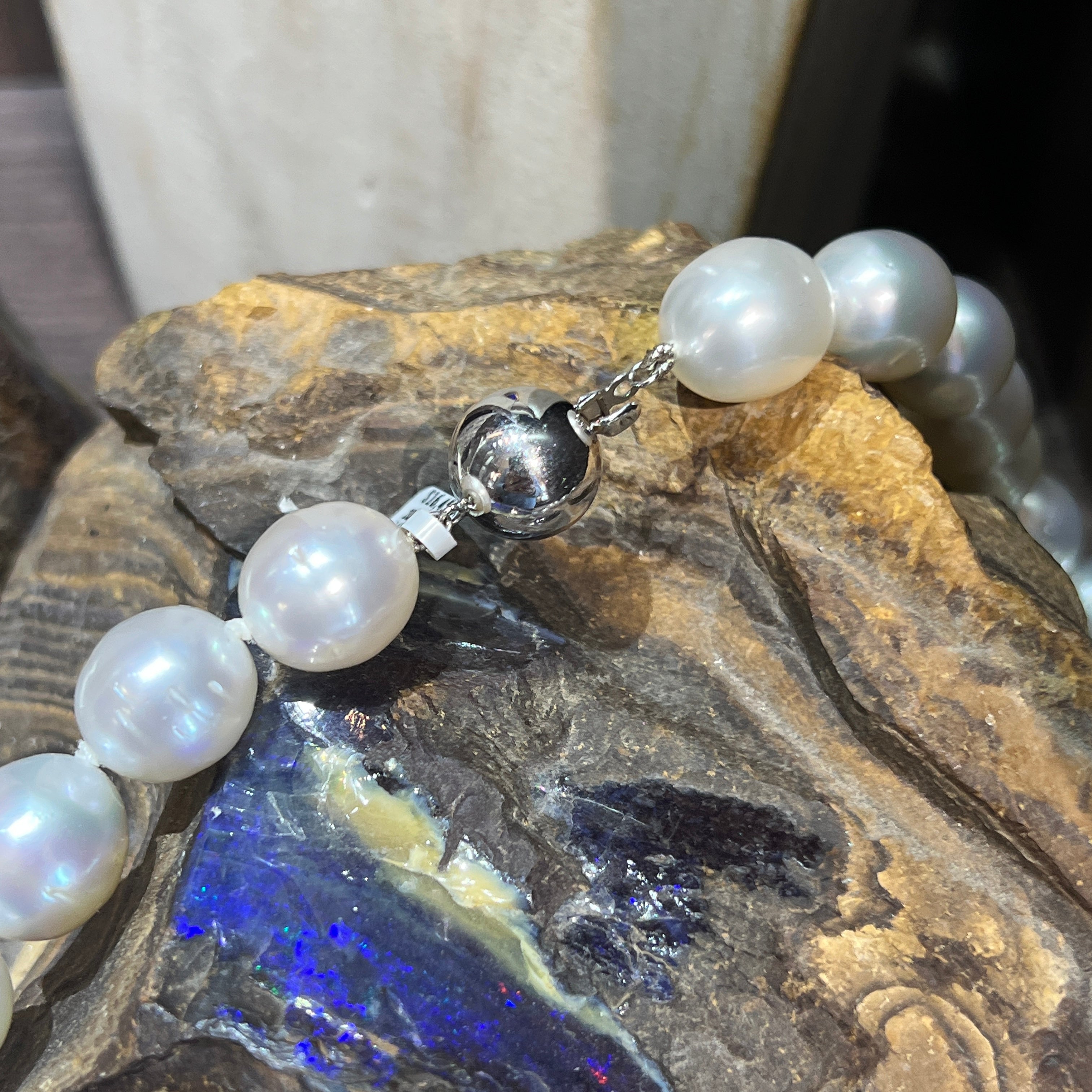 The 14kt white gold ball clasp on the white South Sea pearl strand