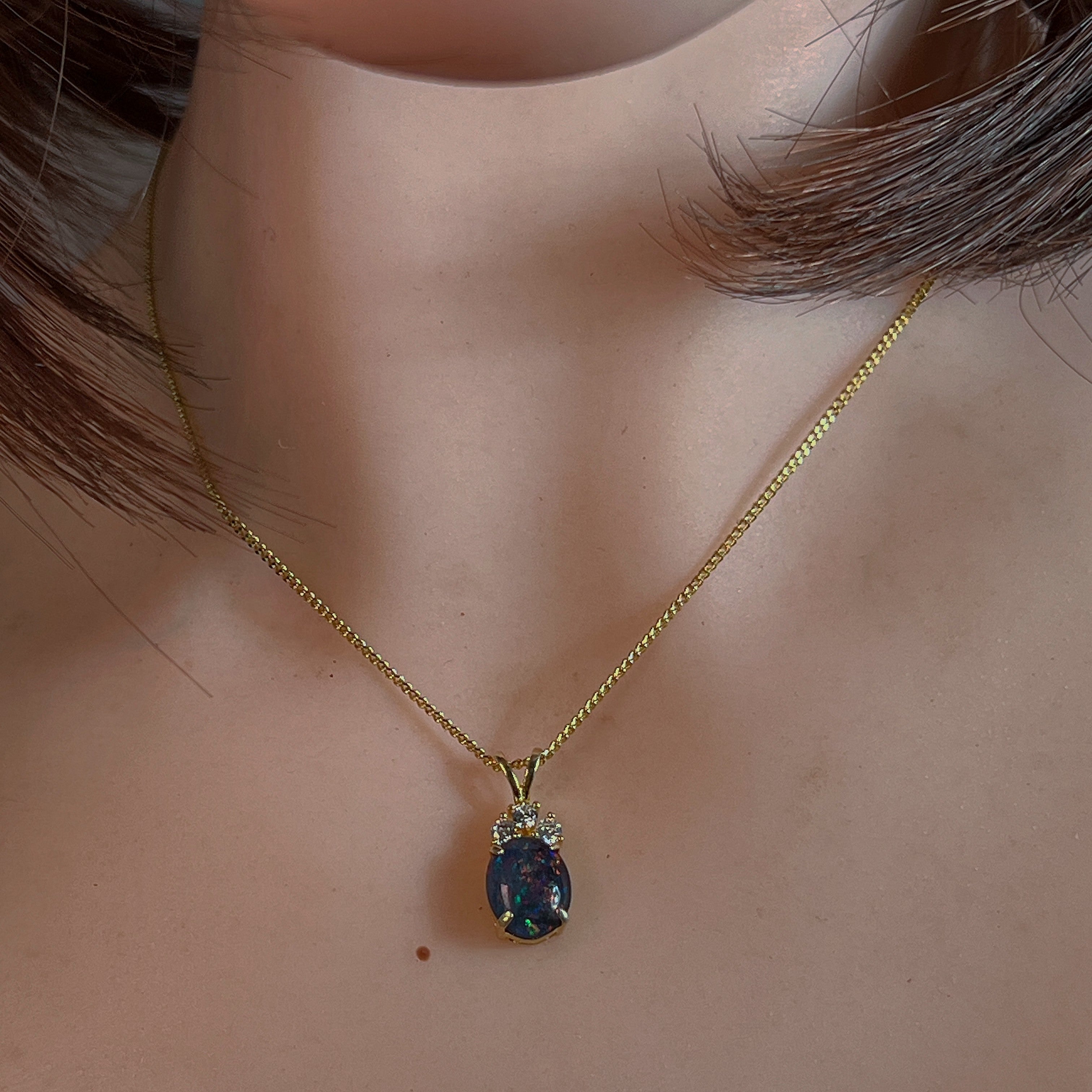 10x8mm opal triplet pendant worn at the neck on a fine gold-plated chain