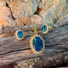 Opal triplet halo pendant and 7x5mm cluster earrings in gold-plated silver against driftwood