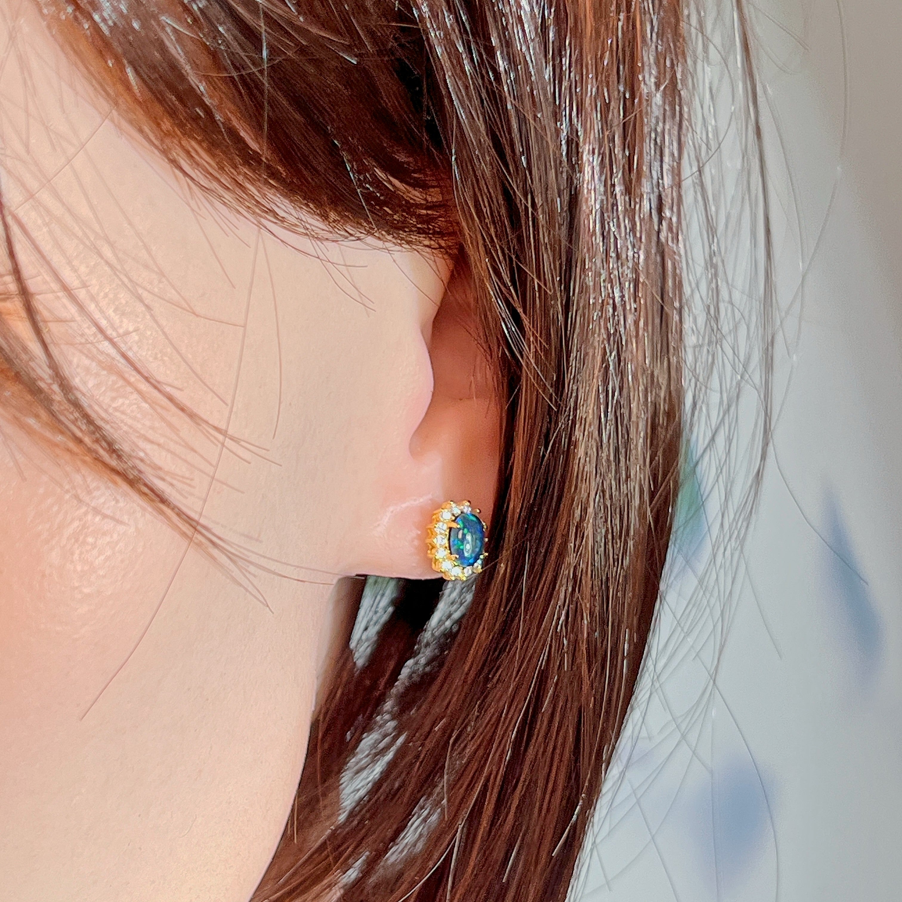 Gold-plated silver opal triplet halo stud worn on the ear, side profile view