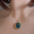 18x13mm opal triplet halo pendant worn at the neck on a gold-plated chain