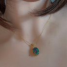 Oval opal triplet pendant with X-shaped bail worn at the neck, close view