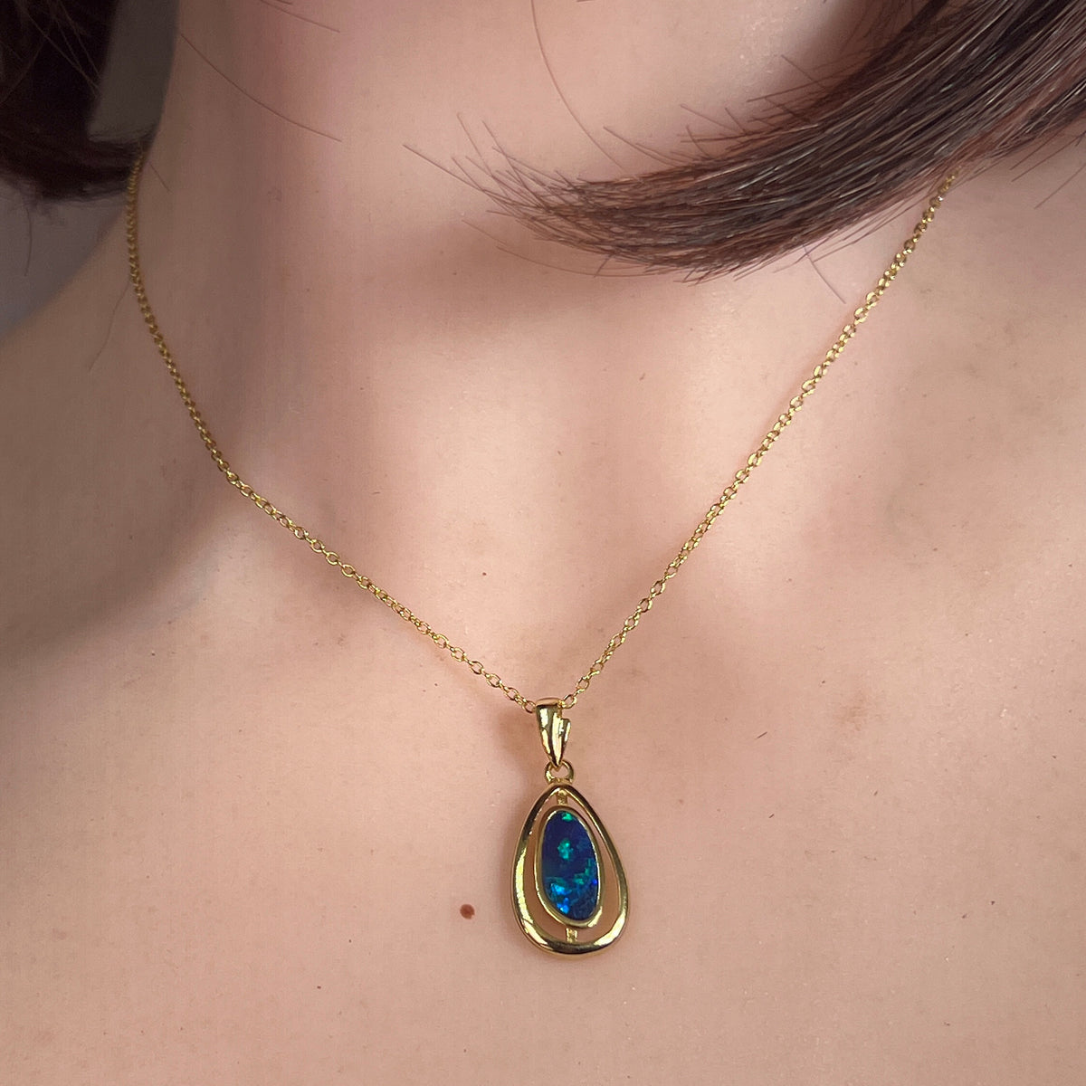 Worn Australian opal doublet pendant in yellow gold-plated silver, blue and green, 11.5 x 5.5mm