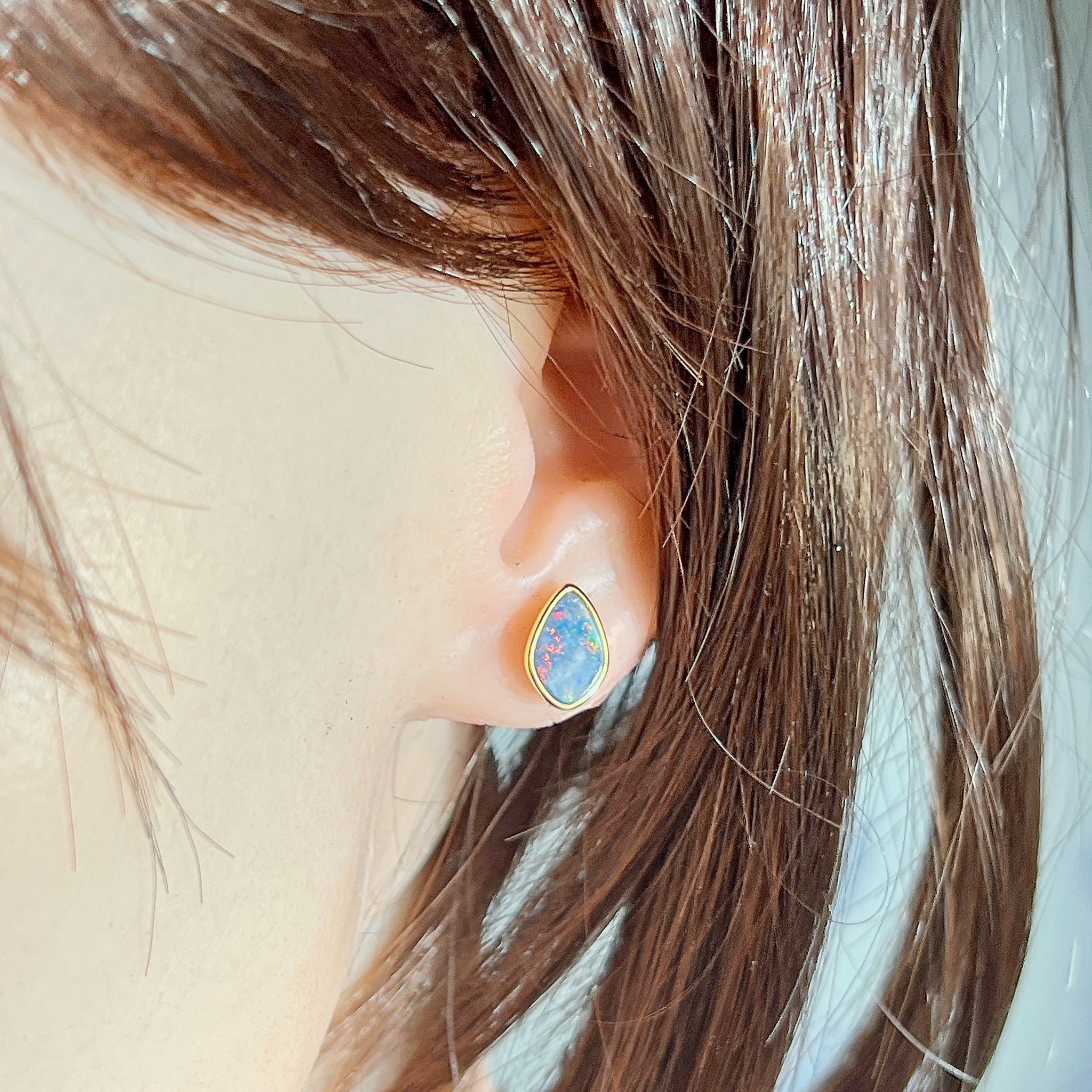 freeform Australian opal doublet earrings worn, yellow gold-plated silver, red, blue and green