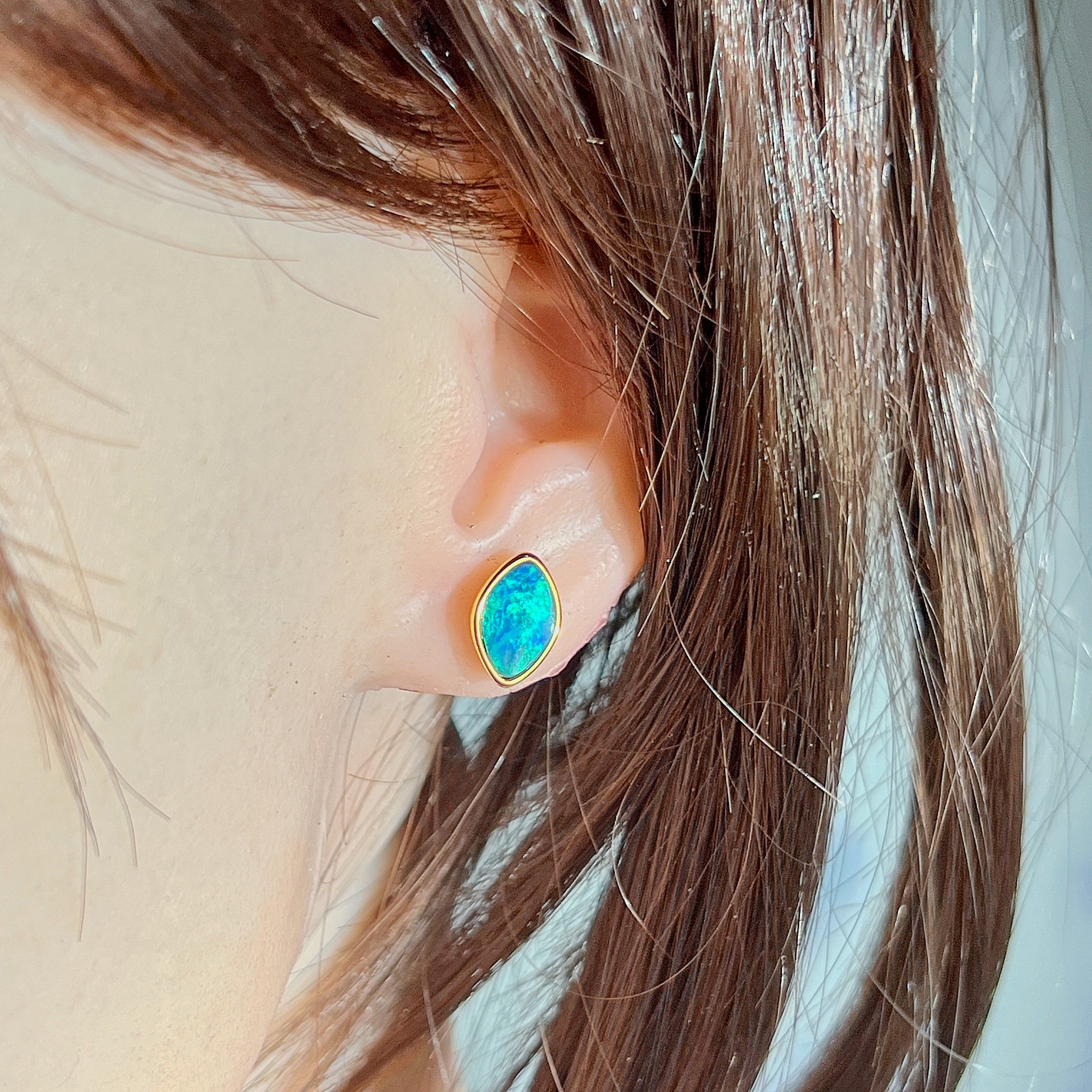 11.5 x 7.5mm marquise Australian opal doublet earrings worn on the ear, yellow gold-plated silver