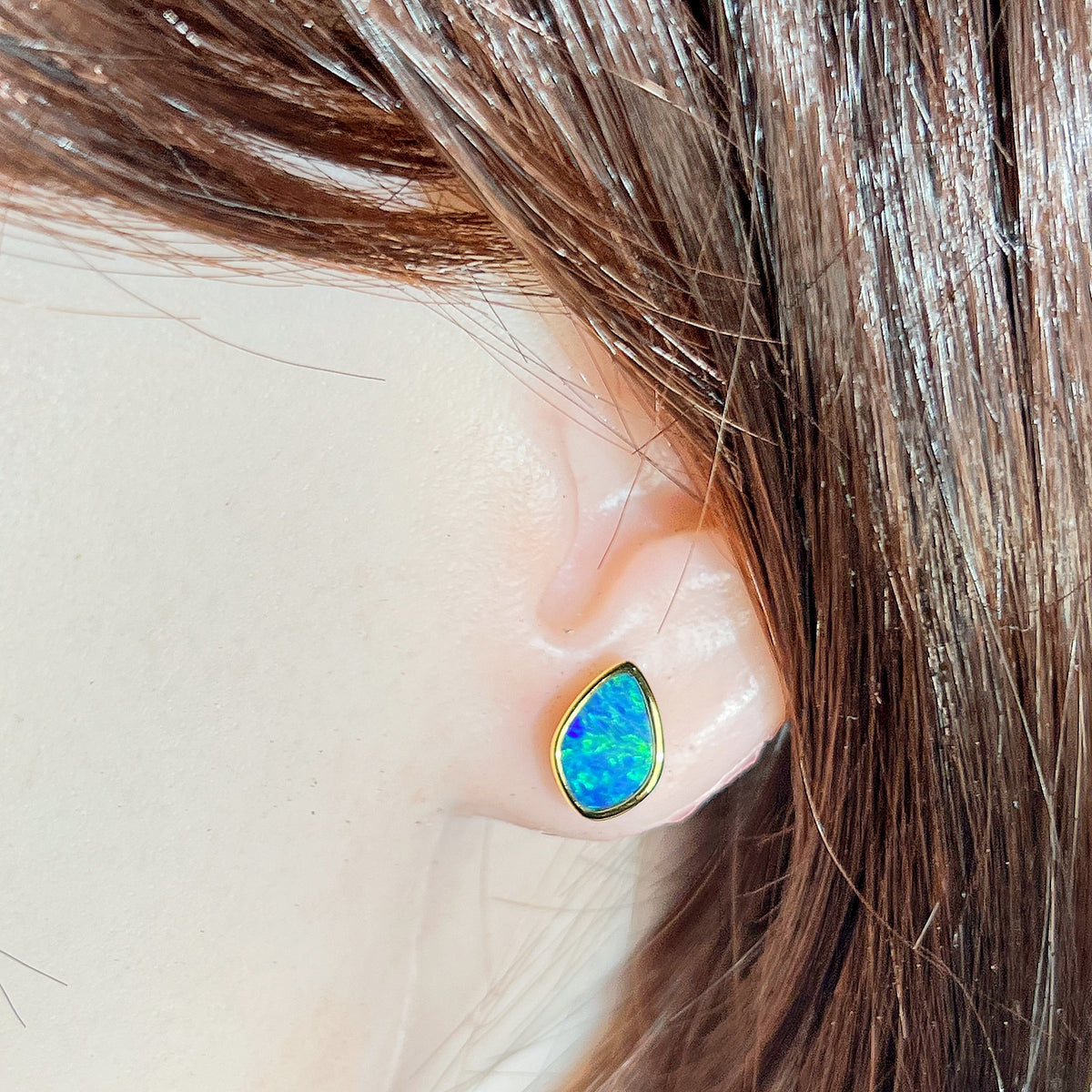 11 x 7.5mm marquise Australian opal doublet earrings worn on the ear, yellow gold-plated silver