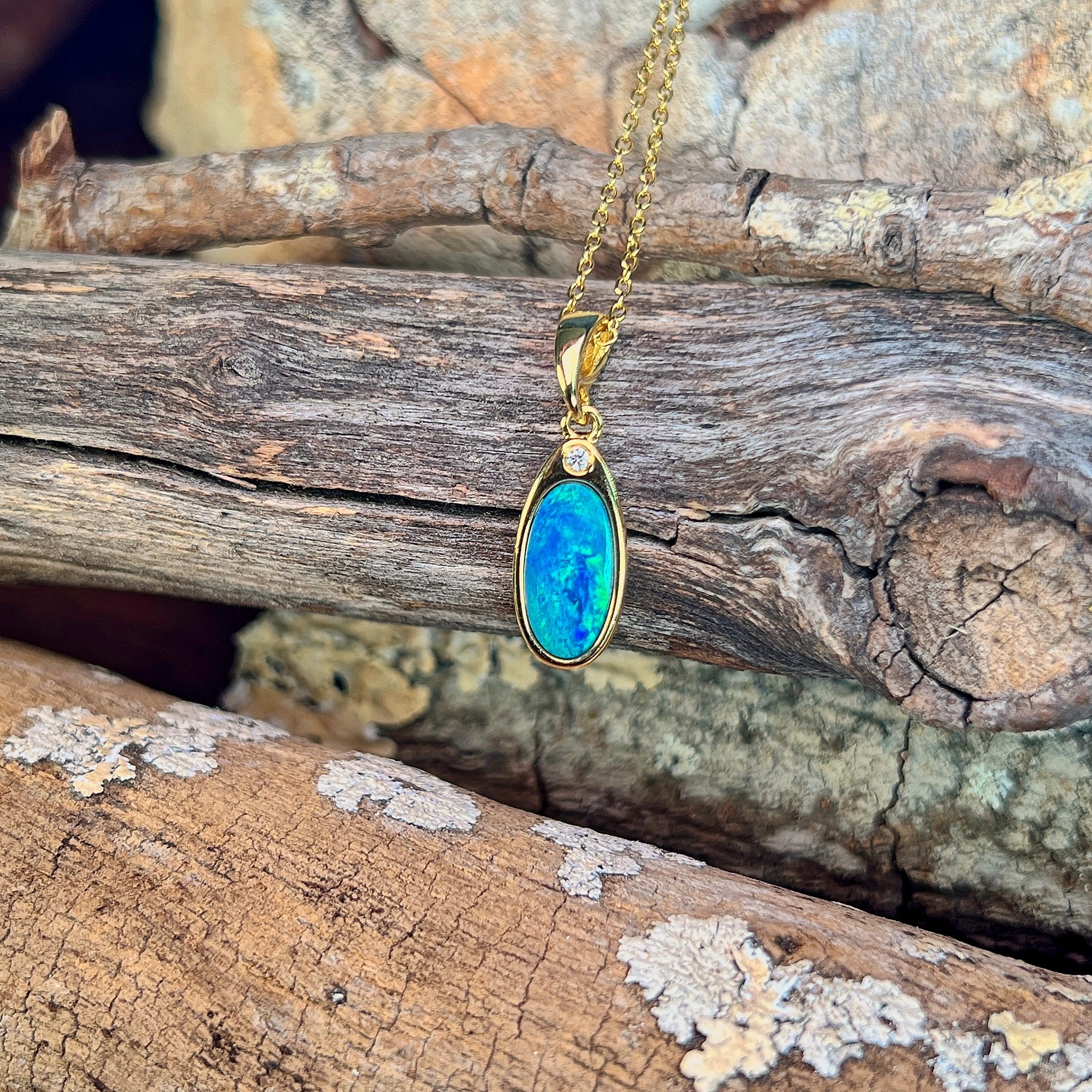 blue and green play-of-colour in a 12 x 6.5mm oval Australian opal doublet pendant