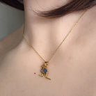 6 x 4mm oval Australian opal doublet pendant worn at the neck, yellow gold-plated silver