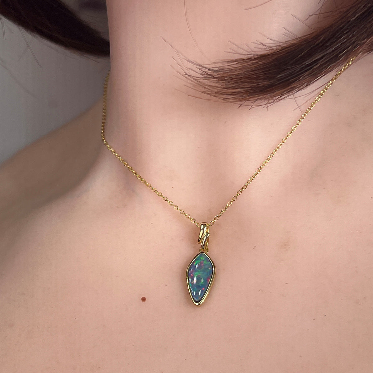 Australian opal doublet pendant worn at the neck, yellow gold-plated silver, 16 x 8mm oval stone
