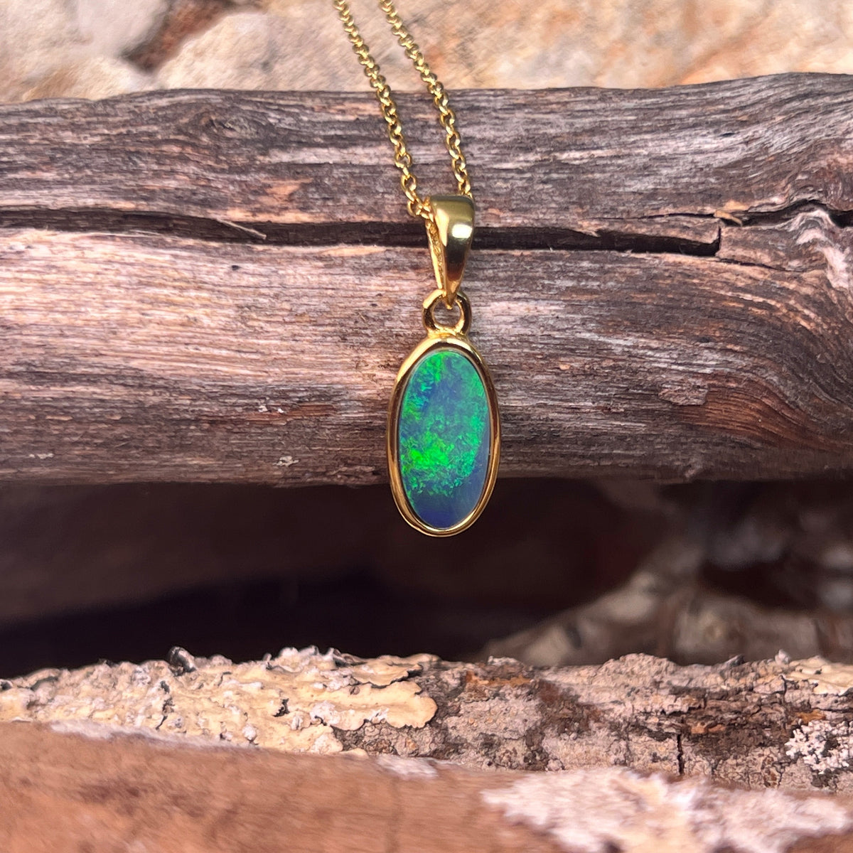 blue and green play-of-colour in a 12 x 6mm oval Australian opal doublet pendant