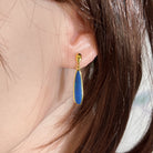 22 x 5.5mm pear-shaped Australian opal doublet earrings worn on the ear, yellow gold-plated silver