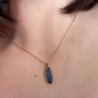 pear-shaped Australian opal doublet pendant in yellow gold-plated silver, worn at the neck
