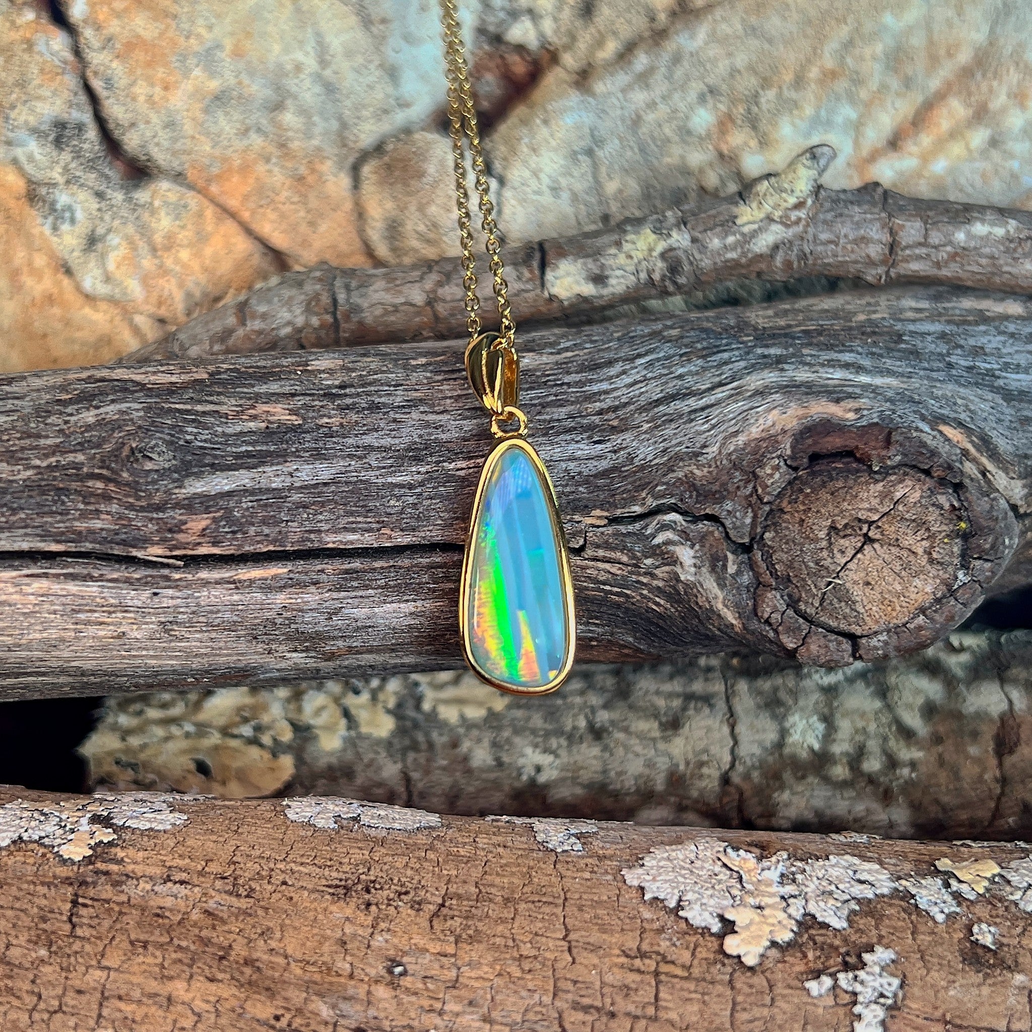 Australian opal doublet pendant, yellow gold-plated silver, 17 x 6mm stone showing green, blue, red and yellow