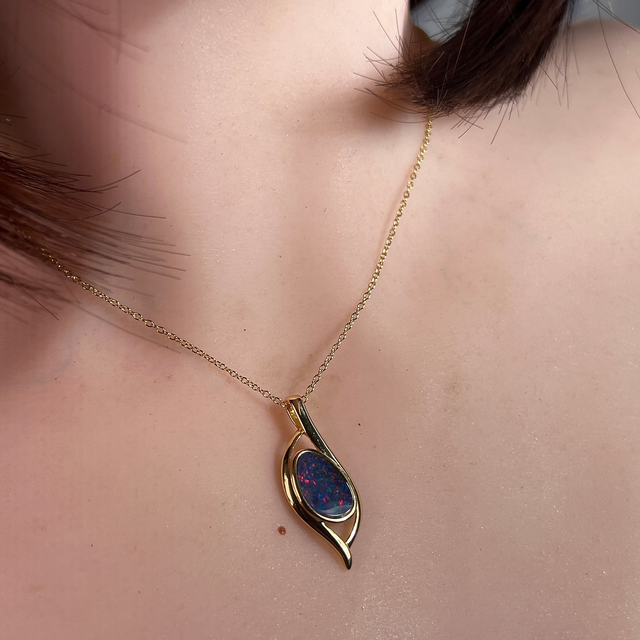 Worn Australian opal doublet pendant in yellow gold-plated silver, red and blue, 12 x 8mm