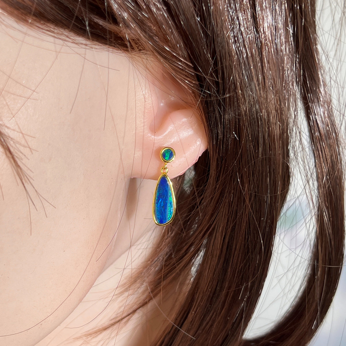 round Australian opal doublet earrings in yellow gold-plated silver, worn on the ear