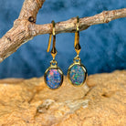 Front view of yellow gold plated sterling silver hook earrings with blue green opal triplets above sandstone