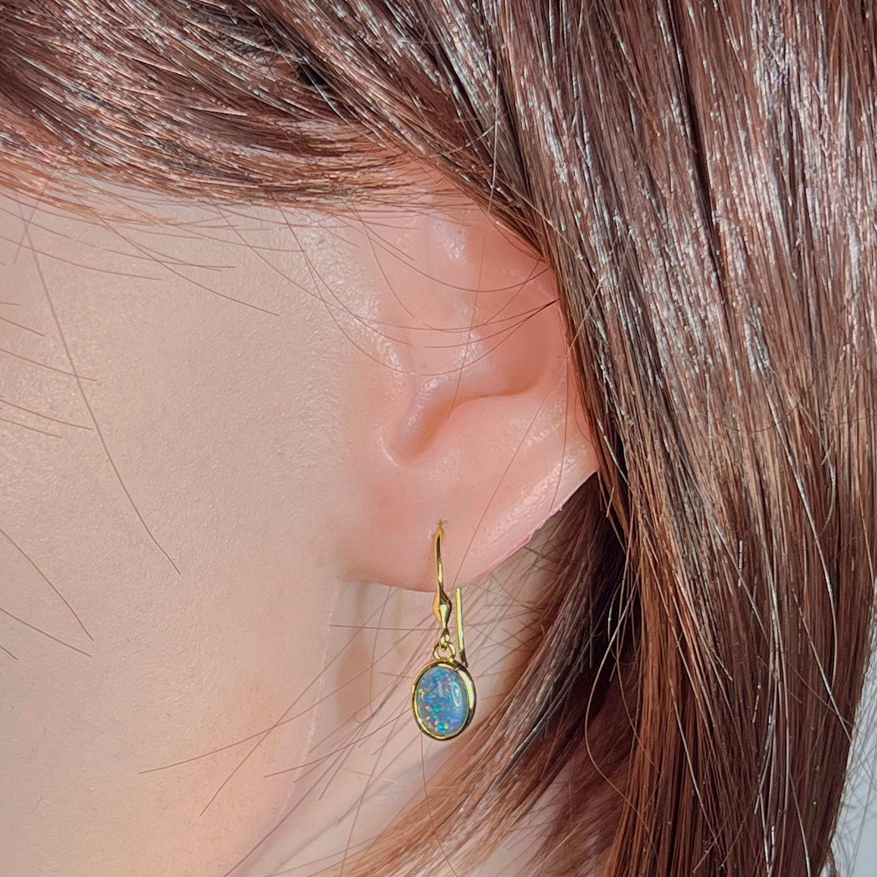 Model wearing the yellow gold plated opal triplet hook earring, showing drop length