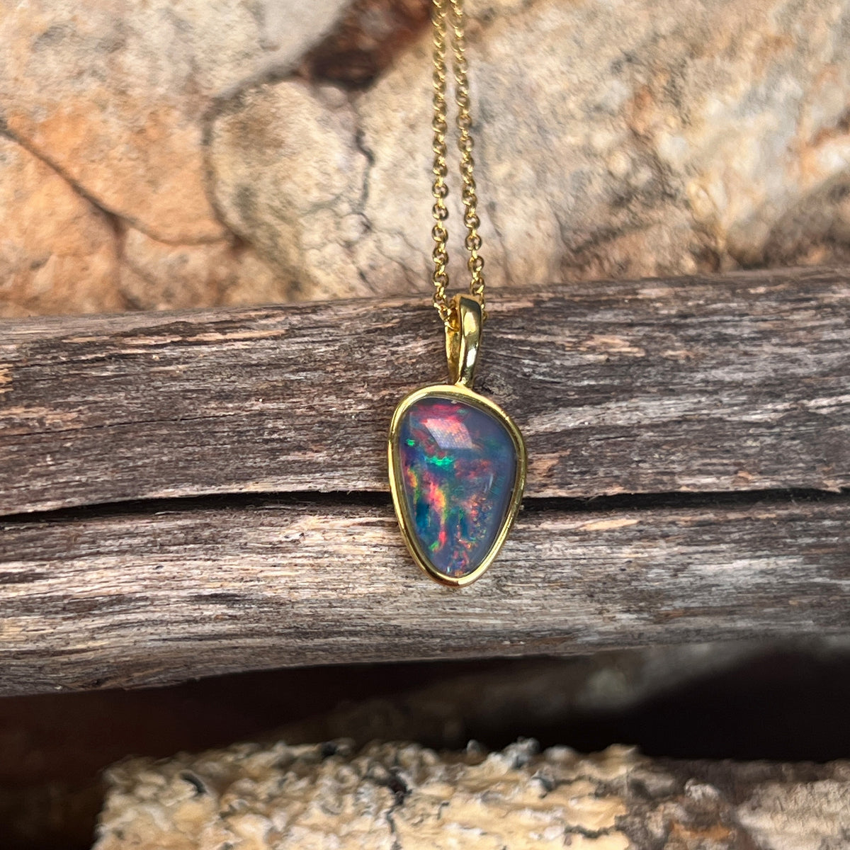 Australian opal triplet pendant, yellow gold-plated silver, 12 x 8mm stone showing blue, red and green