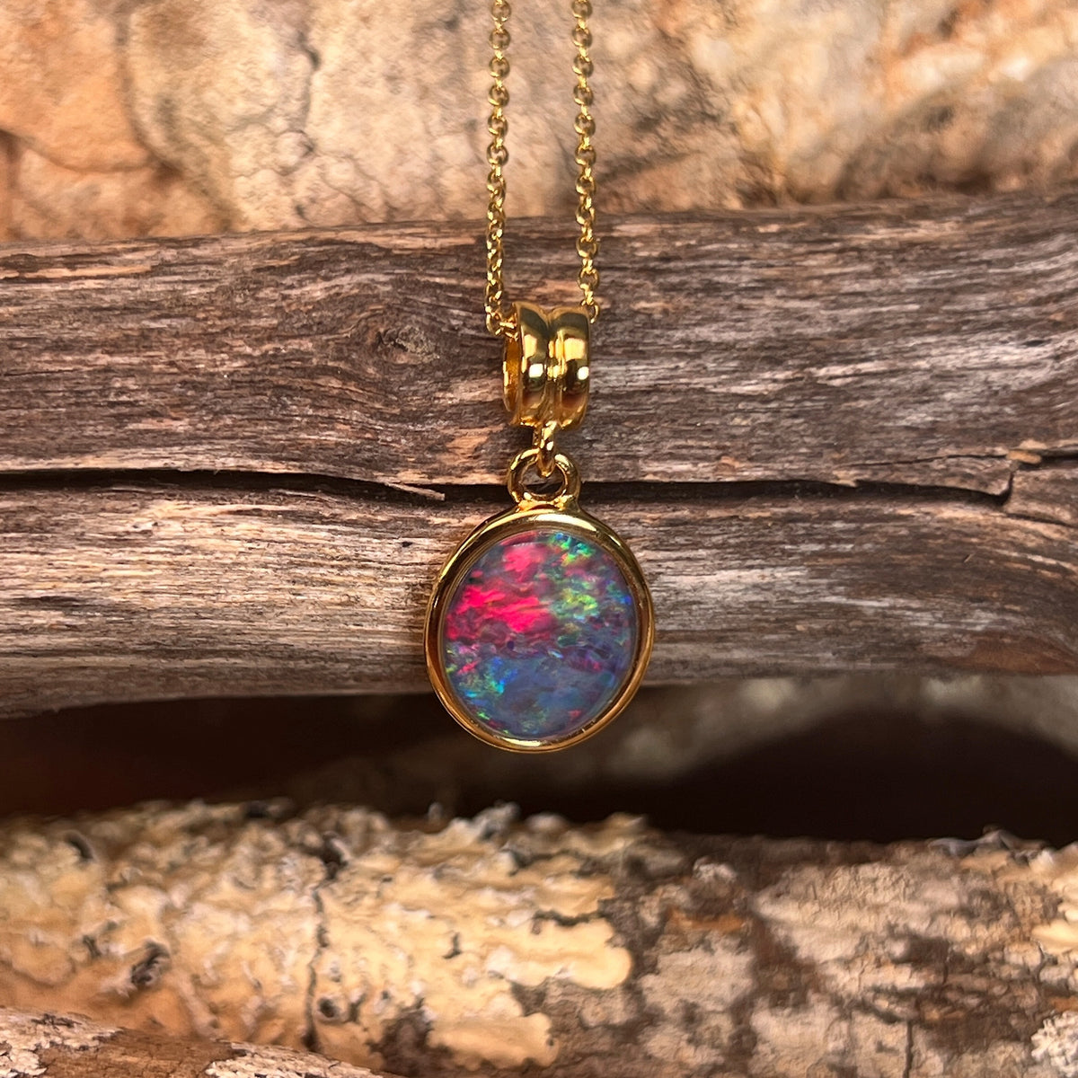 Australian opal triplet pendant, yellow gold-plated silver, 14 x 10mm stone showing blue, red and green