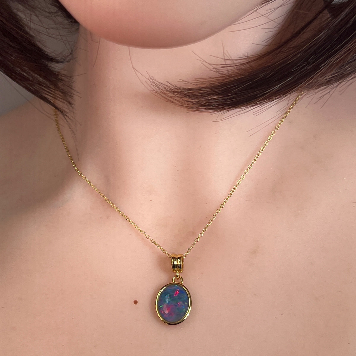 Worn Australian opal triplet pendant in yellow gold-plated silver, blue, red and green, 14 x 10mm